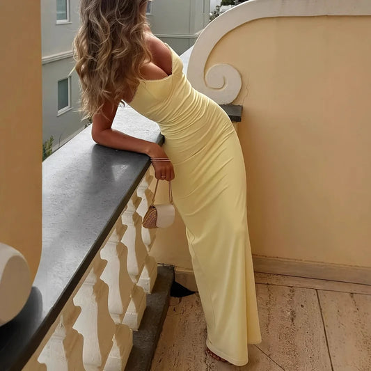 Vestido longo amarelo com decote V e costas abertas, perfeito para verão e praia.